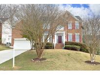 Charming brick two-story home with attached garage and well-maintained lawn at 122 Banyon Tree Ln, Cary, NC 27513