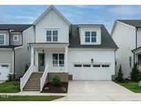 Charming two-story home featuring white siding, a welcoming front porch, and an attached two-car garage at 1225 Barreto Drive Dr, Wendell, NC 27591