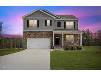 Charming two-story home featuring stone accents, gray siding, and a well-maintained lawn at 140 Baker Farm Dr, Youngsville, NC 27596