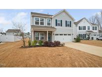 Charming two-story home featuring light siding, dark shutters, and a well-maintained lawn at 1408 Ardsley Ct, Fuquay Varina, NC 27526