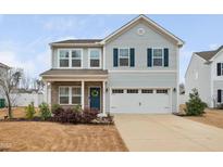 Charming two-story home featuring a welcoming front porch and a two-car garage at 1408 Ardsley Ct, Fuquay Varina, NC 27526