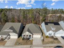 An aerial view shows a well-kept neighborhood with manicured lawns and homes backing to trees at 1713 Wrenn Rd, Durham, NC 27703