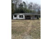Charming single-story home with a covered front porch nestled among mature trees at 186 Frank Cash Rd, Timberlake, NC 27583