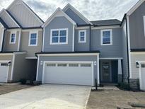 Charming two-story home with a two car garage, light blue exterior, and neatly landscaped yard at 2454 Englemann Dr # 380, New Hill, NC 27562