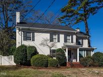 Beautiful white brick two-story home with black shutters and well-manicured landscaping at 2521 St Mary'S St, Raleigh, NC 27609