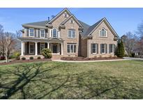 Elegant brick home with a manicured lawn and a welcoming front porch at 301 Highwood Pines Pl, Cary, NC 27519