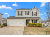 Charming two-story home featuring a two-car garage, well-manicured landscaping, and a welcoming front porch at 315 Huckleberry Loop, Mebane, NC 27302