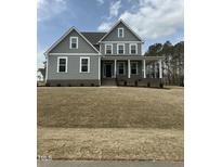 Charming two-story home with a inviting front porch, perfect for relaxing and enjoying the outdoors at 405 Rising Star Dr, Clayton, NC 27520
