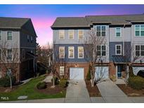 Charming two-story townhome featuring a one-car garage, brick accents, and gray wood-look siding at 4116 Sykes St, Cary, NC 27519