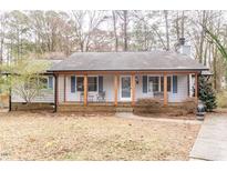 Charming single-story home with a welcoming covered front porch, painted in a light gray at 4311 Abbey Pl, Durham, NC 27707