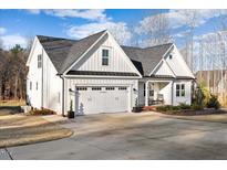 Stunning two-story home with white siding, a gray roof, and a spacious driveway, creating a charming curb appeal at 955 Lynch Rd, Selma, NC 27576