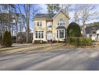 Charming two-story yellow home with well-manicured landscaping at 1 Nicklaus Way, Clayton, NC 27520