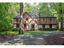 Traditional home with brick and siding facade, complemented by a lush, wooded landscape at 110 Ironwood Pl, Chapel Hill, NC 27514