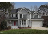 Charming two-story home featuring gray siding, black shutters, and a well-manicured lawn at 113 Hawkscrest Ct, Apex, NC 27502