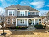 Beautiful two-story home featuring stone accents, gray siding, and a welcoming front porch at 120 Restonwood Dr, Apex, NC 27539