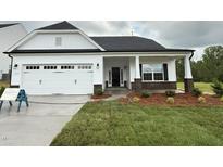 Charming one-story home featuring a white exterior, black door, attached garage and well-maintained front yard at 1794 Parham Dr, Graham, NC 27253