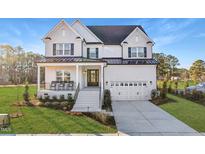 Stately two-story white brick home with a covered front porch and a two-car garage at 3176 Armeria Dr, Apex, NC 27502