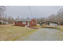 Charming red brick home with a covered carport and a well-maintained front yard at 4166 Nc 119, Mebane, NC 27302