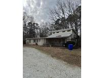 Two-story home with porch, deck and gravel driveway, surrounded by trees at 731 Latimer St, Hillsborough, NC 27278
