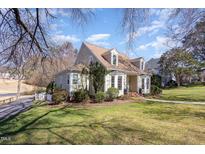Charming two-story home with dormer windows and well-manicured landscaping at 8940 Wildwood Links, Raleigh, NC 27613