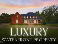 Stunning, two-story brick home with a covered front porch, manicured lawn, and professional landscaping at 93 Shoreline Dr, Princeton, NC 27569