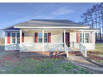 Charming one-story home features a welcoming front porch and red shutters under a clear blue sky at 1125 Field Meadows Dr, Zebulon, NC 27597