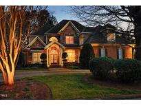 Stunning two-story home featuring stone and brick facade, manicured lawn, and welcoming front porch with a double-door entryway at 12417 Richmond Run Dr, Raleigh, NC 27614