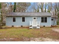 Charming single-story home featuring a light blue exterior and a welcoming white front porch at 136 Dixie Ln, Youngsville, NC 27596