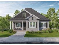 Charming single-story home boasts gray siding, black shutters, inviting front porch, and well-manicured landscaping at 15 Bourbon St, Fuquay Varina, NC 27526