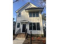 Charming two-story home with white siding, black trim, and brick stairs leading to the front door at 2214 Woodrow St, Durham, NC 27705