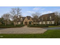 Stately stone and white brick home with mature landscaping and circular driveway at 266 Perfect Moment Dr, Durham, NC 27713