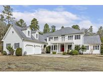 Stately two-story home featuring a red front door, second story balcony, and attached two-car garage at 419 Eagle Point Rd, Pittsboro, NC 27312