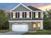 Charming two-story home featuring a brick-accented facade, attached garage and manicured lawn at 505 Providence Springs Ln, Fuquay Varina, NC 27526