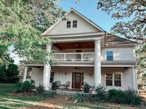 Charming two-story home with a covered front porch and second story balcony lined with columns at 606 E Mason St, Franklinton, NC 27525