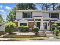 Inviting two-story townhome featuring a brick facade and well-maintained landscaping at 7708 Falcon Rest Cir, Raleigh, NC 27615