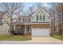 Charming home featuring stone accents, a two-car garage, and well-maintained landscaping at 8242 Marshall Brae Dr, Raleigh, NC 27616