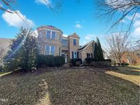 Beautiful brick home features manicured landscaping, a front yard and a sunny blue sky at 9100 Palm Bay Cir, Raleigh, NC 27617