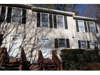Tan townhouse exterior with dark shutters and matching wooden staircases, front door decorations add a personal touch at 106 Weatherstone Dr # B, Chapel Hill, NC 27514
