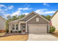 Charming home featuring a two-car garage, well-maintained lawn, and inviting front entrance under a blue sky at 1252 Magic Hollow Rd, Durham, NC 27713