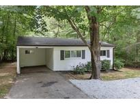 Charming one-story home featuring a carport, a light-colored brick exterior, and a well-maintained landscaped yard at 1706 Us Hwy 70A E, Hillsborough, NC 27278