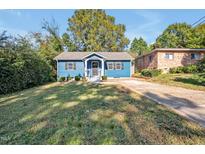 Charming single-story blue home with a well-maintained lawn and inviting front porch at 206 Justice Heights St, Apex, NC 27502