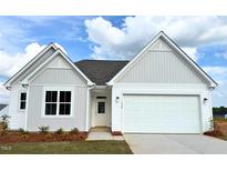Charming single-story home featuring white siding, a two-car garage, and lush front lawn at 338 Tormore Dr, Homesite 123, Sanford, NC 27330