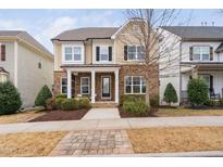 Charming two-story home featuring a stone facade, covered porch, and well-manicured landscaping at 3924 Overcup Oak Ln, Cary, NC 27519