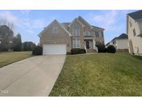 Charming two-story brick home featuring an attached two-car garage and well-manicured lawn at 4 Strowd Ct, Durham, NC 27703