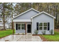Charming single-story home featuring light gray siding, black shutters, and a welcoming front porch at 507 W Edwards St, Princeton, NC 27569