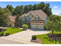 Beautiful two-story home showcasing a well-manicured lawn, three-car garage, and traditional design at 6205 Roles Saddle Dr, Rolesville, NC 27571