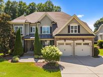 Charming two-story home with a manicured lawn, two-car garage, and beautiful landscaping at 6205 Roles Saddle Dr, Rolesville, NC 27571