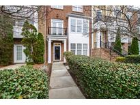 Charming brick townhome featuring a well-manicured front yard and a welcoming entrance with a small balcony at 9206 Wooden Rd, Raleigh, NC 27617