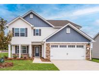 Charming two-story home with white siding, stone accents, and an attached two-car garage at 102 Wilderness Ct, Mebane, NC 27302