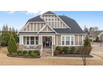 Charming home featuring a welcoming front porch, manicured landscaping, and classic architectural details at 1024 Traditions Ridge Dr, Wake Forest, NC 27587